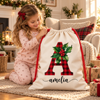 Personalised A and Amelia holly Santa sack with a child in a cosy Christmas reading nook